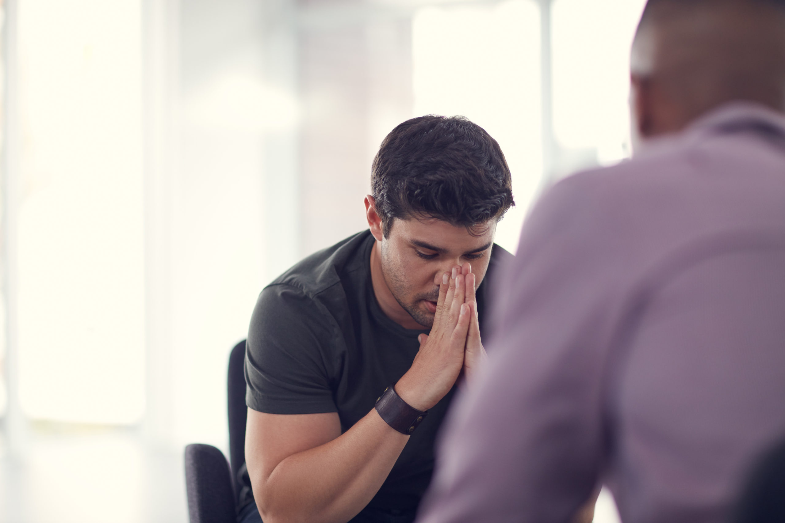 i just need somebody to talk to Shot of an unhappy young man talking with a colleague